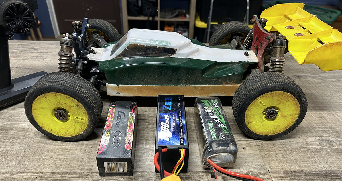 Three LiPo batteries next to an RC buggy.